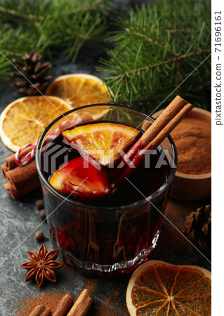 Glass of mulled wine and ingredients on black smokey background Glass of mulled wine and ingredients on black smokey background 71696161