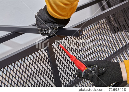 Handyman is mounting metal flat pack furniture using screwdriver. Handyman is mounting metal flat pack furniture using screwdriver. 71698438