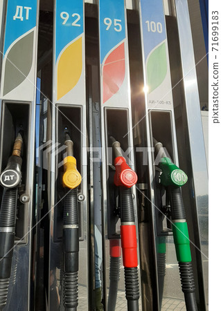 Multicolored fuel pistols on fuel station. Multicolored fuel pistols on fuel station. 71699183