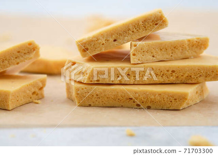 Dessert caramel honeycomb toffee on a white background. Dessert caramel honeycomb toffee on a white background. 71703300