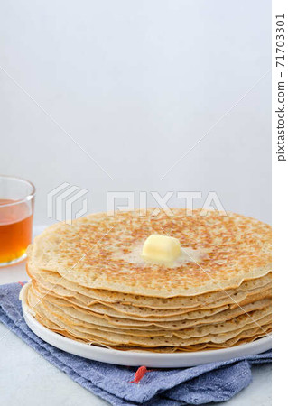 Crepes, thin pancakes with honey and butter on a white plate. Close up. Crepes, thin pancakes with honey and butter on a white plate. Close up. 71703301