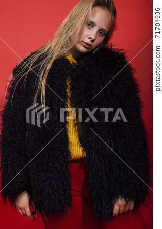 young pretty fashion teenage girl on bright red background, happy smiling lifestyle people concept 71704936