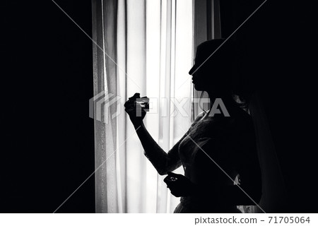 black and white silhouette of an elegant bride at the window black and white silhouette of an elegant bride at the window 71705064