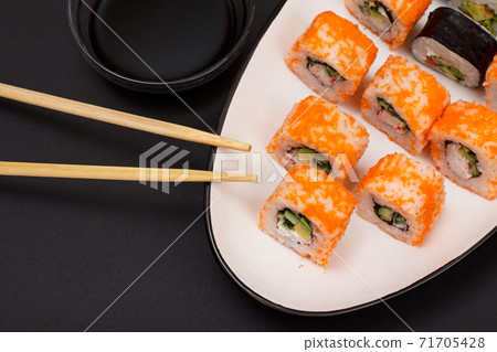 Uramaki California. Sushi rolls, wooden sticks and bowl with soy sauce. Uramaki California. Sushi rolls, wooden sticks and bowl with soy sauce. 71705428