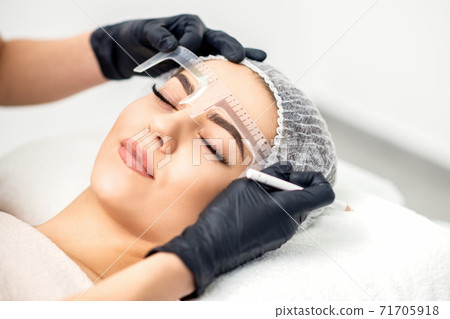 Beautician measuring brows with ruler Beautician measuring brows with ruler 71705918