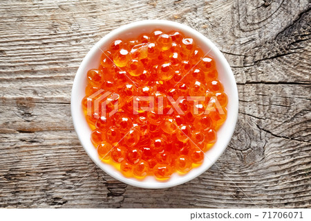 Bowl of red caviar on wood, from above 71706071