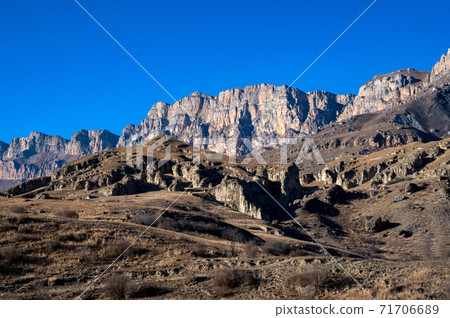Rocks and dry grass in North Caucasus mountains in autumn on sunny day 71706689