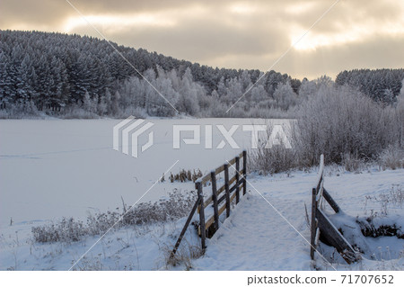 Wooden entrance to the forest near the frozen lake near the forest Wooden entrance to the forest near the frozen lake near the forest 71707652