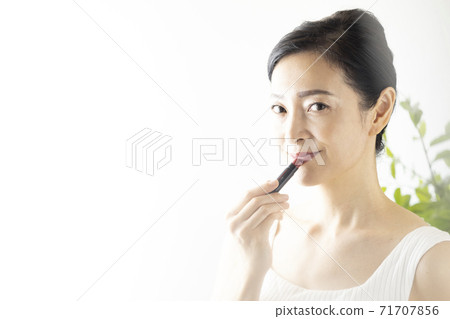 Beauty image Woman applying lipstick 71707856