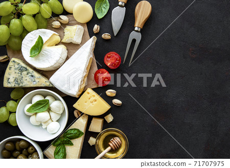 Various types of cheese, grapes, honey and snacks Various types of cheese, grapes, honey and snacks 71707975