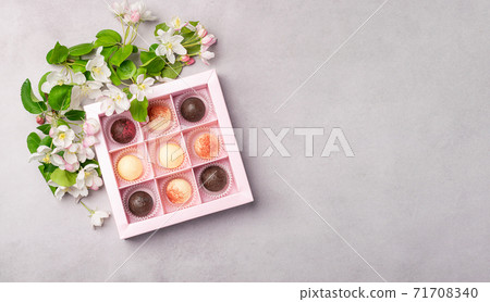 Chocolate candies in a festive box on a gray background. Holiday concept Chocolate candies in a festive box on a gray background. Holiday concept 71708340