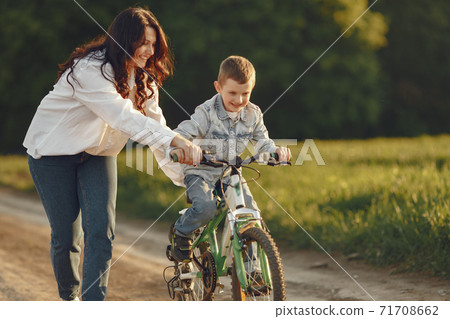 Mother with little son playing in a autumn field Mother with little son playing in a autumn field 71708662