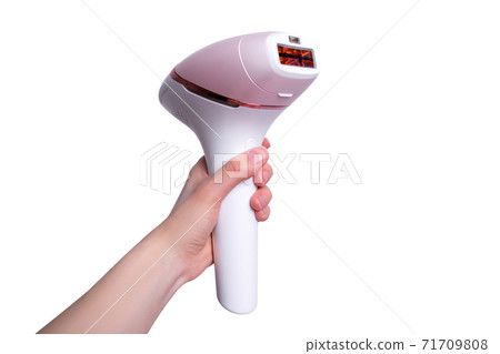 The girl holds a photoepilator in her hand. A device for removing unwanted hair isolated on white. The girl holds a photoepilator in her hand. A device for removing unwanted hair isolated on white. 71709808