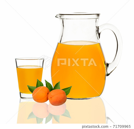 apricot juice in a glass and carafe on a white background apricot juice in a glass and carafe on a white background 71709965