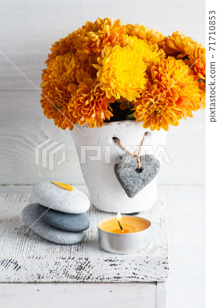 Orange chrysanthemum flowers with pebbles 71710853