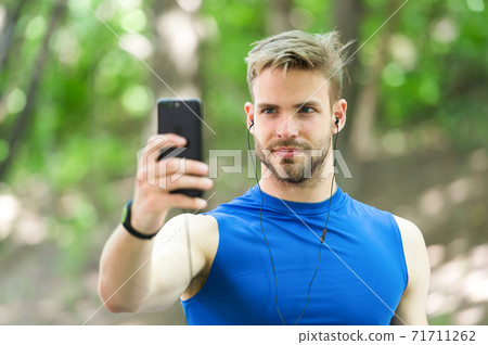 Sport gadget concept. Athlete mobile phone set up playlist before runnig Sport gadget concept. Athlete mobile phone set up playlist before runnig 71711262