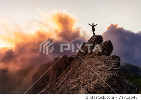 Adventurous Girl on top of a Mountain Peak Adventurous Girl on top of a Mountain Peak 71712645