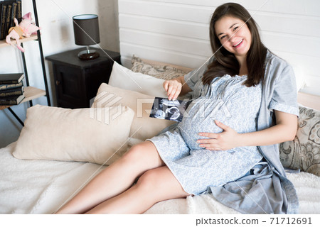Pregnant woman holding ultrasound scan. Pregnancy health concept. Pregnant woman holding ultrasound scan. Pregnancy health concept. 71712691