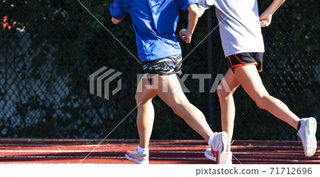 Two runners training together running on a track Two runners training together running on a track 71712696