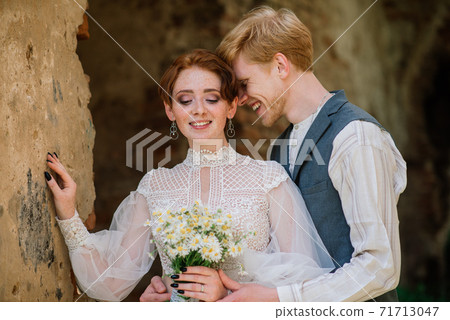 Nice redhead young just married happy couple kissing in the sunset outdoors 71713047