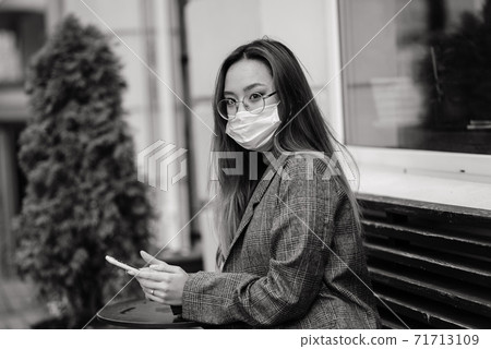 Asian woman with surgical mask face protection. She commutes between home and workplace in the city 71713109