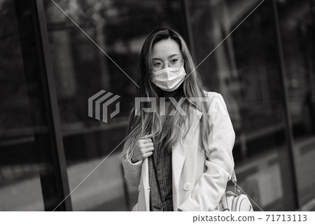 Asian woman with surgical mask face protection. She commutes between home and workplace in the city Asian woman with surgical mask face protection. She commutes between home and workplace in the city 71713113