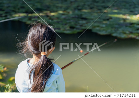 Girl fishing in the fishing pond 71714211