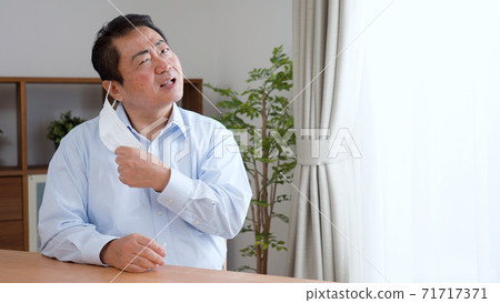 Middle-aged man removing the mask Middle-aged man removing the mask 71717371