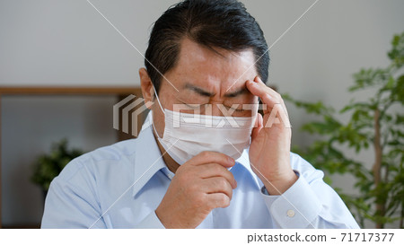 Middle-aged man coughing 71717377
