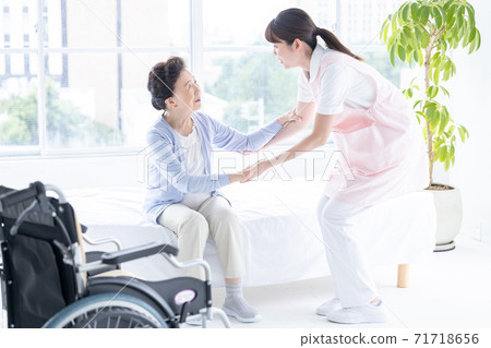 Long-term care image: A caregiver who helps senior women stand up 71718656