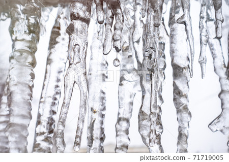 Transparent icicles on a white background. Abstract ice background. Transparent icicles on a white background. Abstract ice background. 71719005