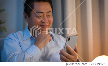 Middle-aged man using a smartphone 71719426
