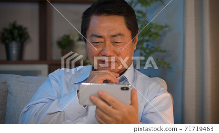 中年男子在他的智能手機上觀看視頻 71719463