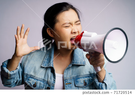 Asian woman shouting with megaphone isolated over white background. 71720514