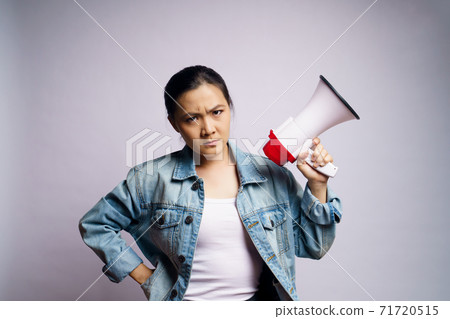 Asian woman shouting with megaphone isolated over white background. Asian woman shouting with megaphone isolated over white background. 71720515