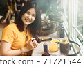 Young Asian food blogger Smiling toward to camera with happily while sitting and child out at the cafe. 71721544