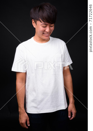 Young handsome Asian man against black background Young handsome Asian man against black background 71722646