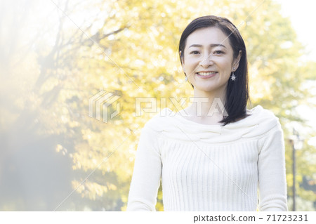 Middle woman smiling in the autumn park 71723231