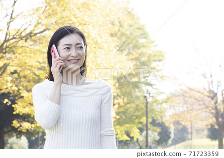淺談秋天公園智能手機的中年女人 淺談秋天公園智能手機的中年女人 71723359