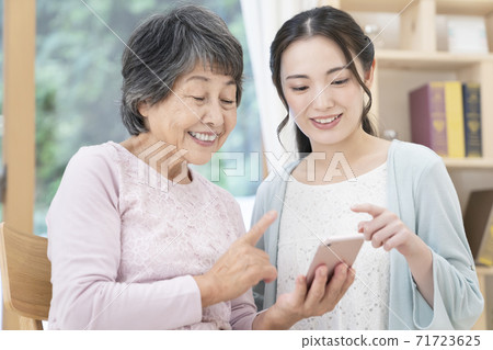 Senior women and young women smartphones 71723625
