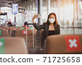 A passenger businesswoman wearing face mask doing selfie while waiting on boarding at the airport, lifestyle new normal customer after covid-19 pandemic. 71725658