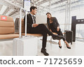 A passenger businessman and woman talking with happy while waiting on boarding at the airport with luggage nearby, lifestyle business people. 71725659
