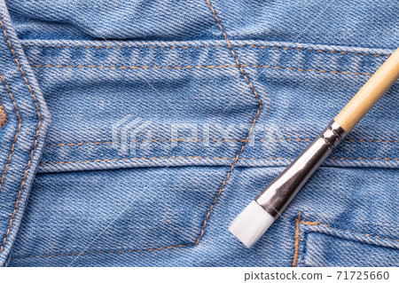Tassel on blue jeans. The concept of a man repairing a house, painting, building, repairing, DIY, handicraft 71725660