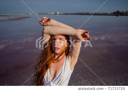 Beautiful young lady with long healthy red hair and cute dress Beautiful young lady with long healthy red hair and cute dress 71725720