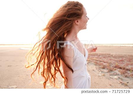 Beautiful young lady with long healthy red hair and cute dress Beautiful young lady with long healthy red hair and cute dress 71725729
