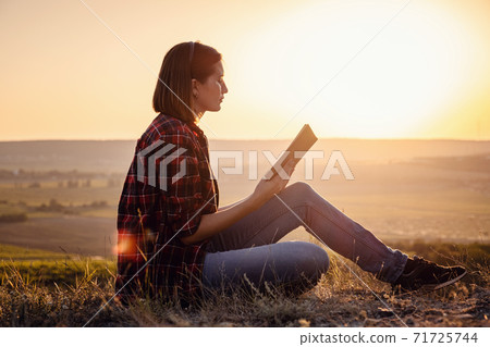 beautiful woman writing into her diary, in the park 71725744
