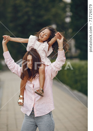 Elegant mother with daughter in a summer park Elegant mother with daughter in a summer park 71726079