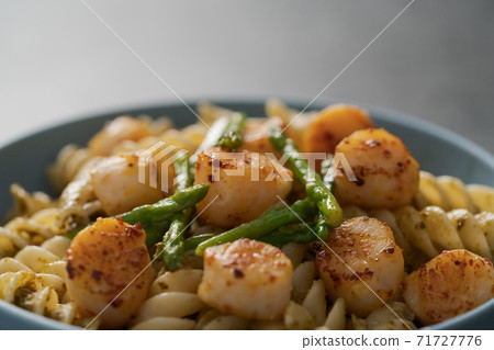 Fusilli pasta with scallops and asparagus in blue bowl closeup Fusilli pasta with scallops and asparagus in blue bowl closeup 71727776