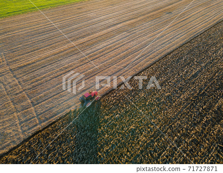 Farmer working in tractor preparing land for sowing 71727871