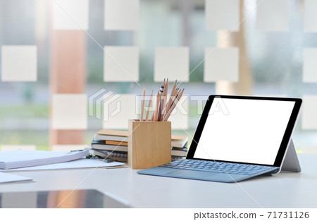Close-up shot of Tablet mockup blank screen on desk in comfortable office. Close-up shot of Tablet mockup blank screen on desk in comfortable office. 71731126